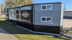 Introducing the revolutionary 8X31 Stub American Dream—a game-changing Ice Castle RV model designed to elevate your outdoor living experience to new heights. Crafted with meticulous attention to detail, the American Dream embodies the essence of luxury, comfort, and practicality, redefining what it means to enjoy life on the water. The hallmark feature of the American Dream is its innovative 48 by 72 outside kitchen slash entertainment area, a first for Ice Castle. Picture yourself enjoying the serenity of the outdoors while whipping up delicious meals in your fully equipped kitchen. Complete with a 110 refrigerator, sink, and a convenient slide-out cooktop, as well as spacious under storage, this outdoor kitchen ensures you have everything you need for your on-the-water adventures right at your fingertips. Step inside the American Dream, and you’ll be greeted by 31 feet of customizable space designed to meet your every need. The front of the American Dream features two 30-inch bunks and a TV hookup, perfect for gaming or entertainment, while the raised floor bathroom offers spaciousness and convenience with its vanity, sink, toilet, and roomy shower. The kitchen is a chef’s delight, boasting stainless steel appliances, a Furrion Cooktop Oven, microwave, large refrigerator, dual sink, and a stylish stone backsplash. With 31 feet at your disposal, the American Dream ensures an abundance of space and storage throughout. Appreciate the convenience of folding barn doors for added privacy from kids or guests. At the rear of the American Dream, a square bay with a fireplace sets the stage for cozy evenings spent with loved ones, while two 68-inch jackknife sofas fold down for additional sleeping space. And let’s not forget the electric lift bed—a perfect solution for a restful evening in your castle. With its dual-axle hydraulic frame, 90-inch sidewalls, and sprawling awning spanning over 20 feet, the American Dream offers the perfect blend of luxury and practicality, making it ideal for year-round family enjoyment. Whether you’re embarking on a weekend getaway or an extended vacation, make your dreams a reality with the American Dream for sale in Starbuck, MN—a true masterpiece of modern RV design.