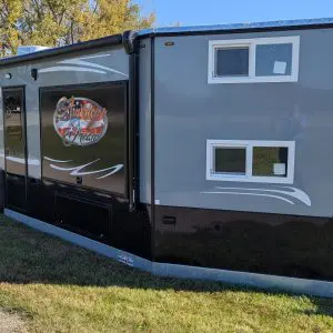 Introducing the revolutionary 8X31 Stub American Dream—a game-changing Ice Castle RV model designed to elevate your outdoor living experience to new heights. Crafted with meticulous attention to detail, the American Dream embodies the essence of luxury, comfort, and practicality, redefining what it means to enjoy life on the water. The hallmark feature of the American Dream is its innovative 48 by 72 outside kitchen slash entertainment area, a first for Ice Castle. Picture yourself enjoying the serenity of the outdoors while whipping up delicious meals in your fully equipped kitchen. Complete with a 110 refrigerator, sink, and a convenient slide-out cooktop, as well as spacious under storage, this outdoor kitchen ensures you have everything you need for your on-the-water adventures right at your fingertips. Step inside the American Dream, and you’ll be greeted by 31 feet of customizable space designed to meet your every need. The front of the American Dream features two 30-inch bunks and a TV hookup, perfect for gaming or entertainment, while the raised floor bathroom offers spaciousness and convenience with its vanity, sink, toilet, and roomy shower. The kitchen is a chef’s delight, boasting stainless steel appliances, a Furrion Cooktop Oven, microwave, large refrigerator, dual sink, and a stylish stone backsplash. With 31 feet at your disposal, the American Dream ensures an abundance of space and storage throughout. Appreciate the convenience of folding barn doors for added privacy from kids or guests. At the rear of the American Dream, a square bay with a fireplace sets the stage for cozy evenings spent with loved ones, while two 68-inch jackknife sofas fold down for additional sleeping space. And let’s not forget the electric lift bed—a perfect solution for a restful evening in your castle. With its dual-axle hydraulic frame, 90-inch sidewalls, and sprawling awning spanning over 20 feet, the American Dream offers the perfect blend of luxury and practicality, making it ideal for year-round family enjoyment. Whether you’re embarking on a weekend getaway or an extended vacation, make your dreams a reality with the American Dream for sale in Starbuck, MN—a true masterpiece of modern RV design.